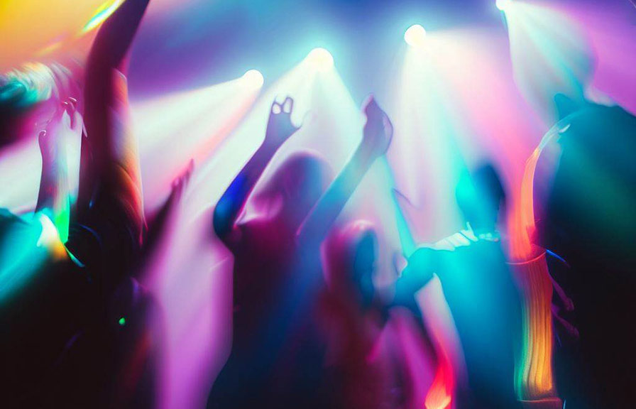 Group of people dancing and having fun at party with colorful lights